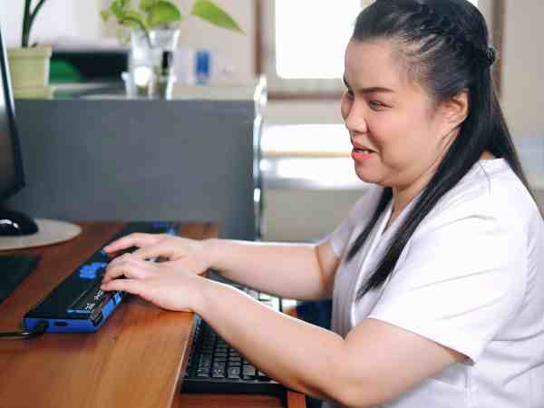 person using computer braille display